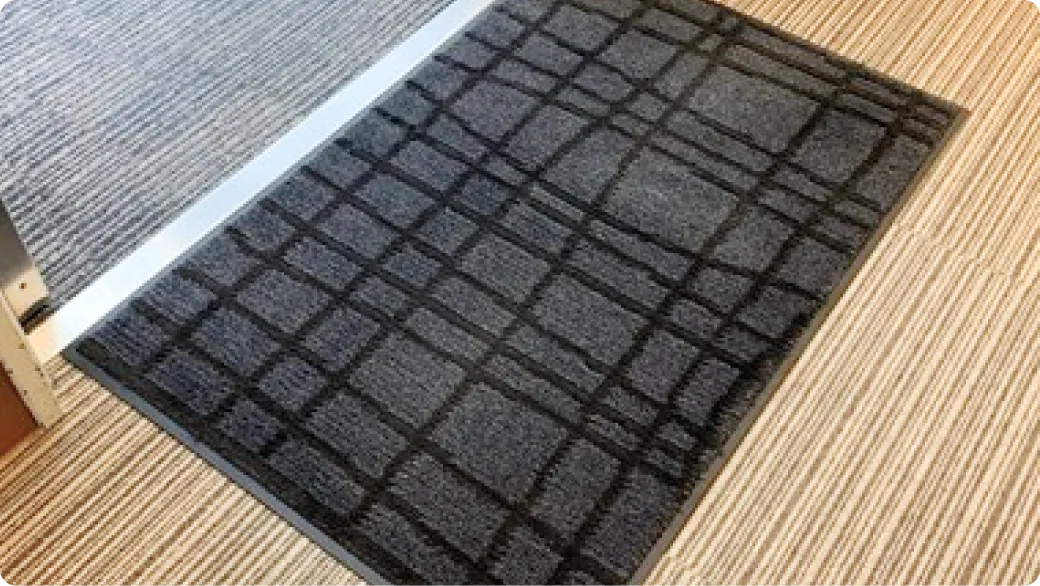 木目フロアに敷かれた濃いグレーの格子柄マット