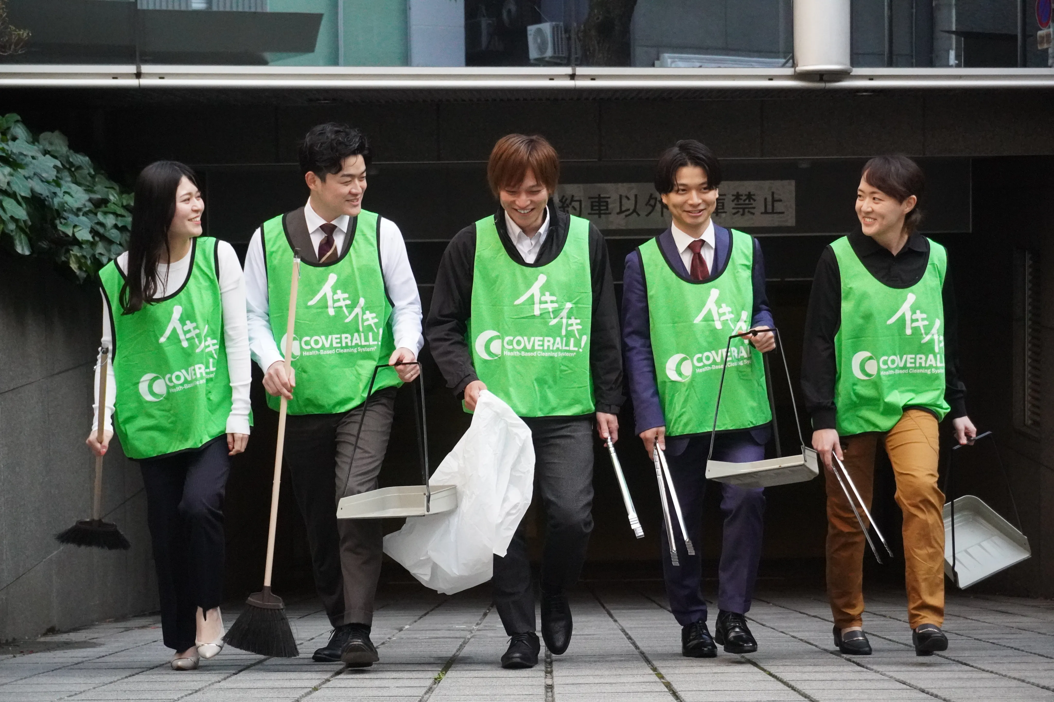 地域住民とスタッフが通りを清掃している様子